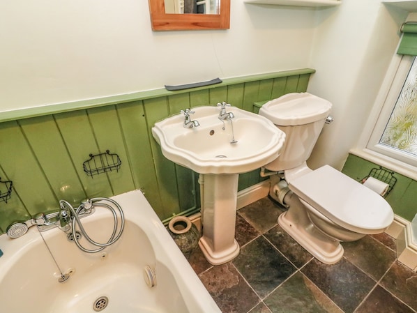 Un baño con bañera, lavabo e inodoro.
