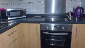 A kitchen with a microwave, oven, and kettle. - The Station Master's Office (Saltburn-by-the-Sea)
