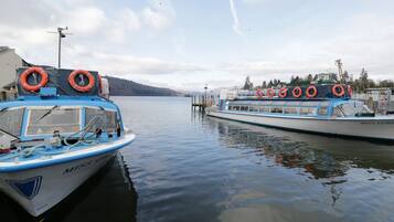 Two boats docked at a marina with lifebuoys on the side of the boats.