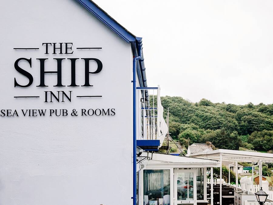 The Ship Inn with a white exterior and a sign indicating it is a pub and rooms.