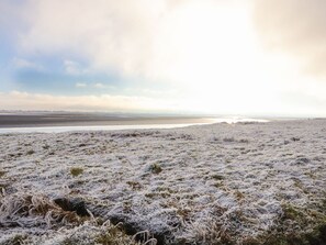 A frosty landscape with a flat terrain and distant water body. - Sonya's Cottage (Wigton)