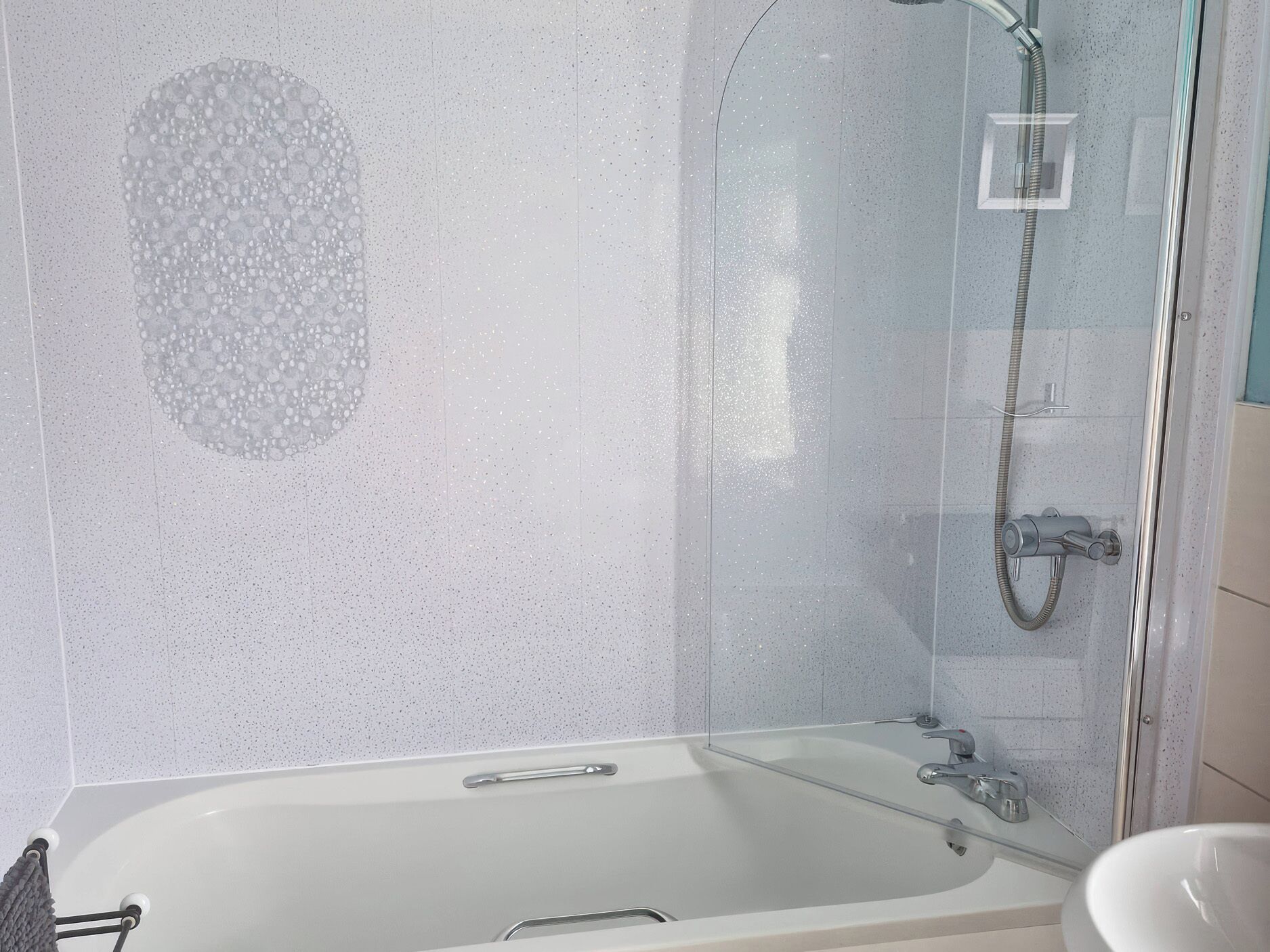 Ein modernes Badezimmer mit einer freistehenden Badewanne, einer Duschkabine und einer gefliesten Wand.