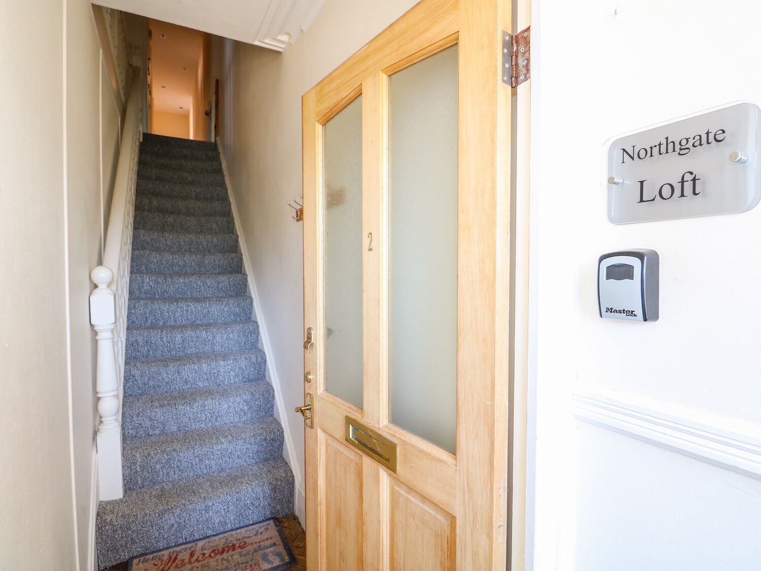 Un escalier menant à une porte portant l’inscription « Northgate Loft ».