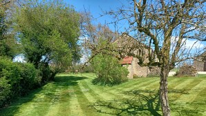 A well-maintained lawn with a stone building in the background.