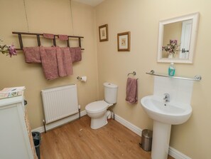 A bathroom with a toilet, sink, and a towel rack with multiple towels. - Erica's 'eaven (York)