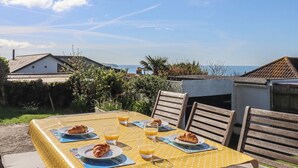 Una mesa con alimentos para el desayuno y vista al mar.