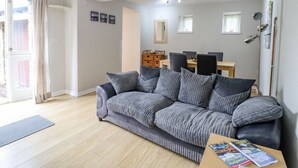 En stue med sofa, spisebord og reol.