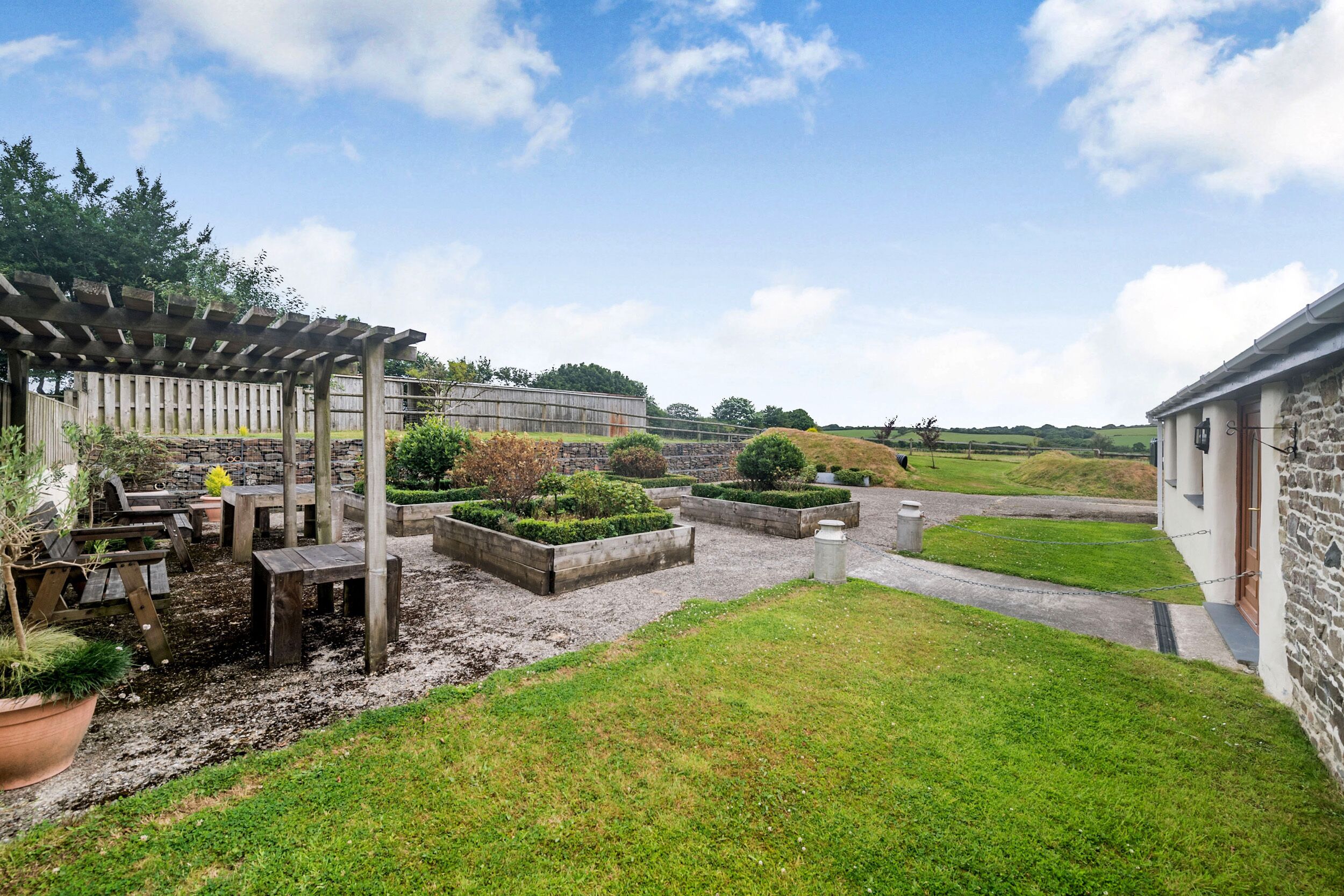 A garden area with a pergola, seating, and planters.