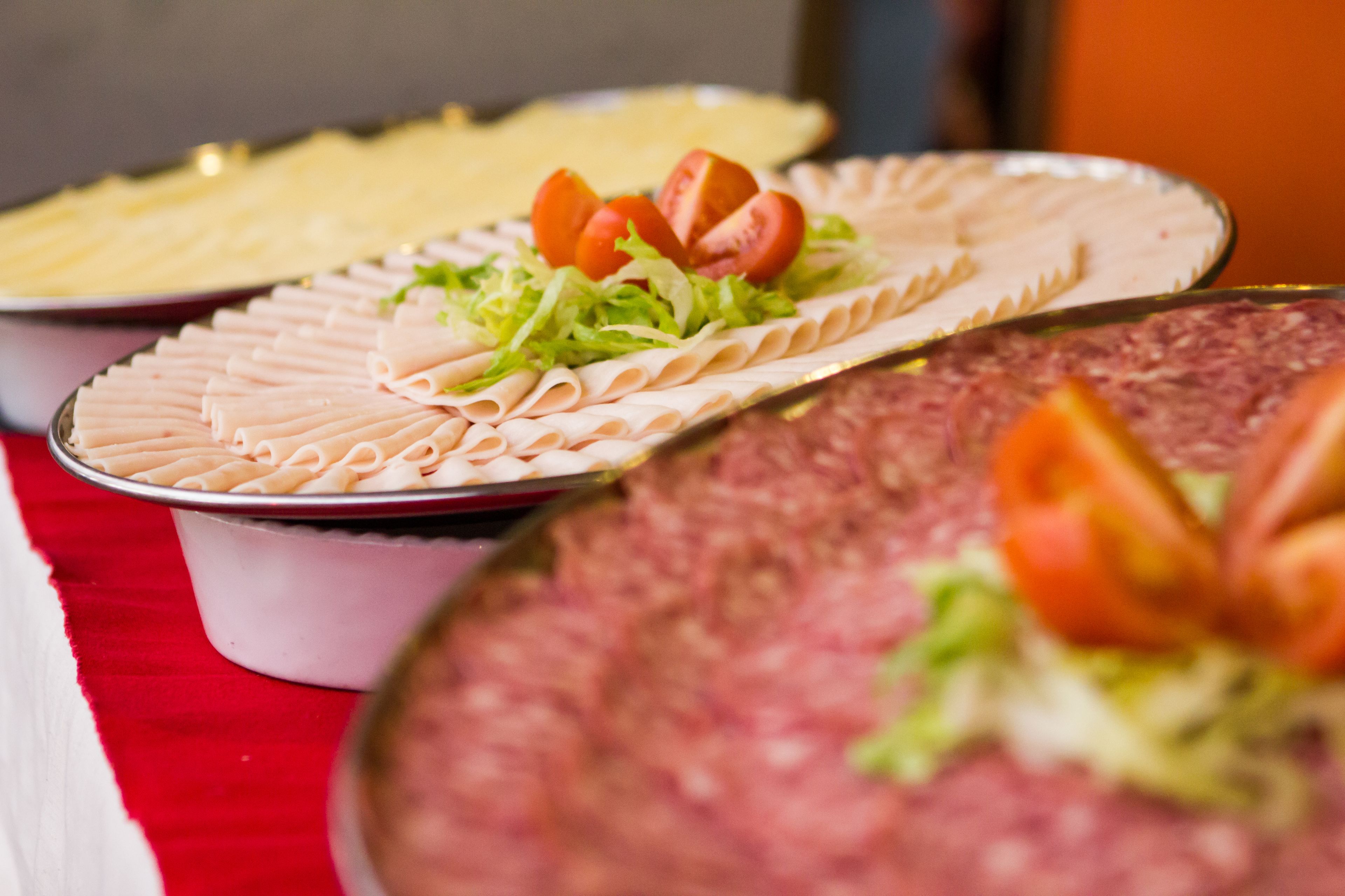 Un buffet con diversi cibi, tra cui salumi e verdure.