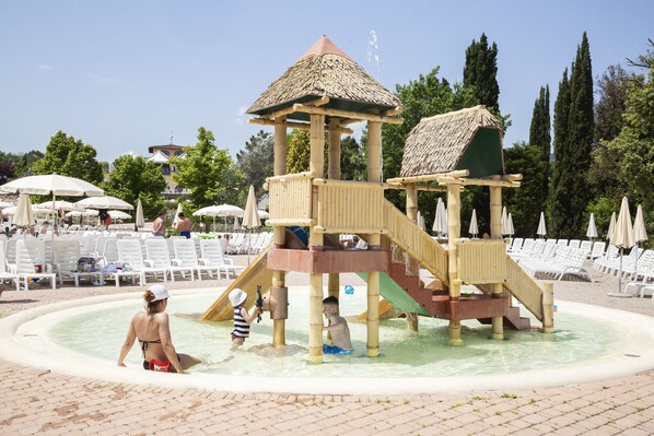 Un espace de jeux aquatiques avec des toboggans et une petite structure en forme de tour.