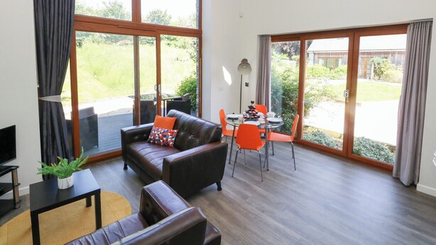 Un vaste espace de vie comprenant un canapé, une table basse et une table à manger pour quatre personnes.