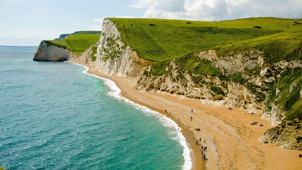 A coastal beach with cliffs and a clear sky. - Budmouth (Weymouth)