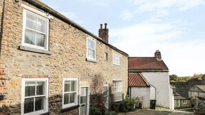 A stone building with multiple windows and a small garden area with potted plants. - 9 Tower Street (Richmond)