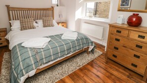A neatly arranged bedroom with a wooden bed, a dresser, and a window with a view. - 9 Tower Street (Richmond)