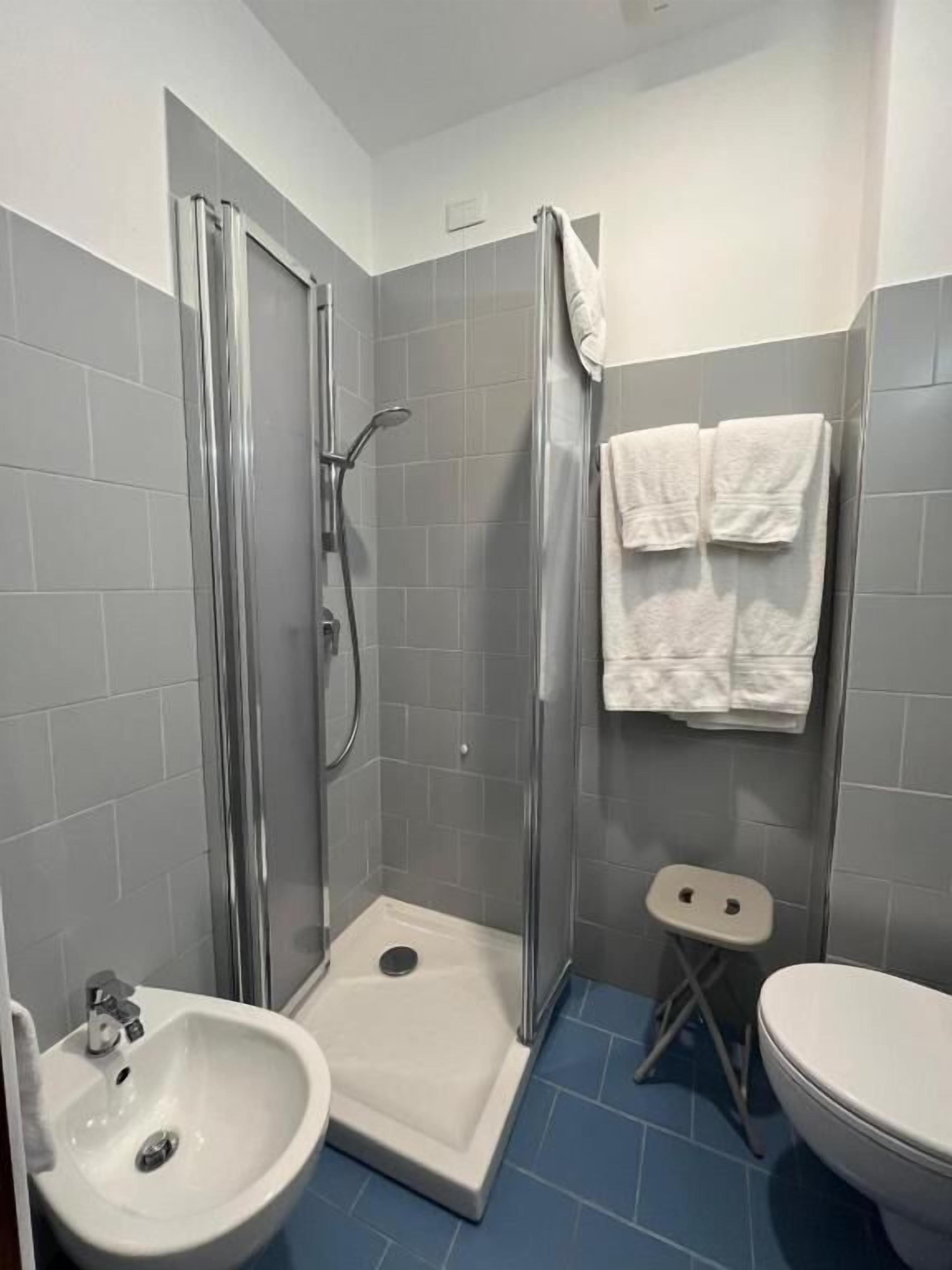 A bathroom with a shower, a sink, and a toilet.