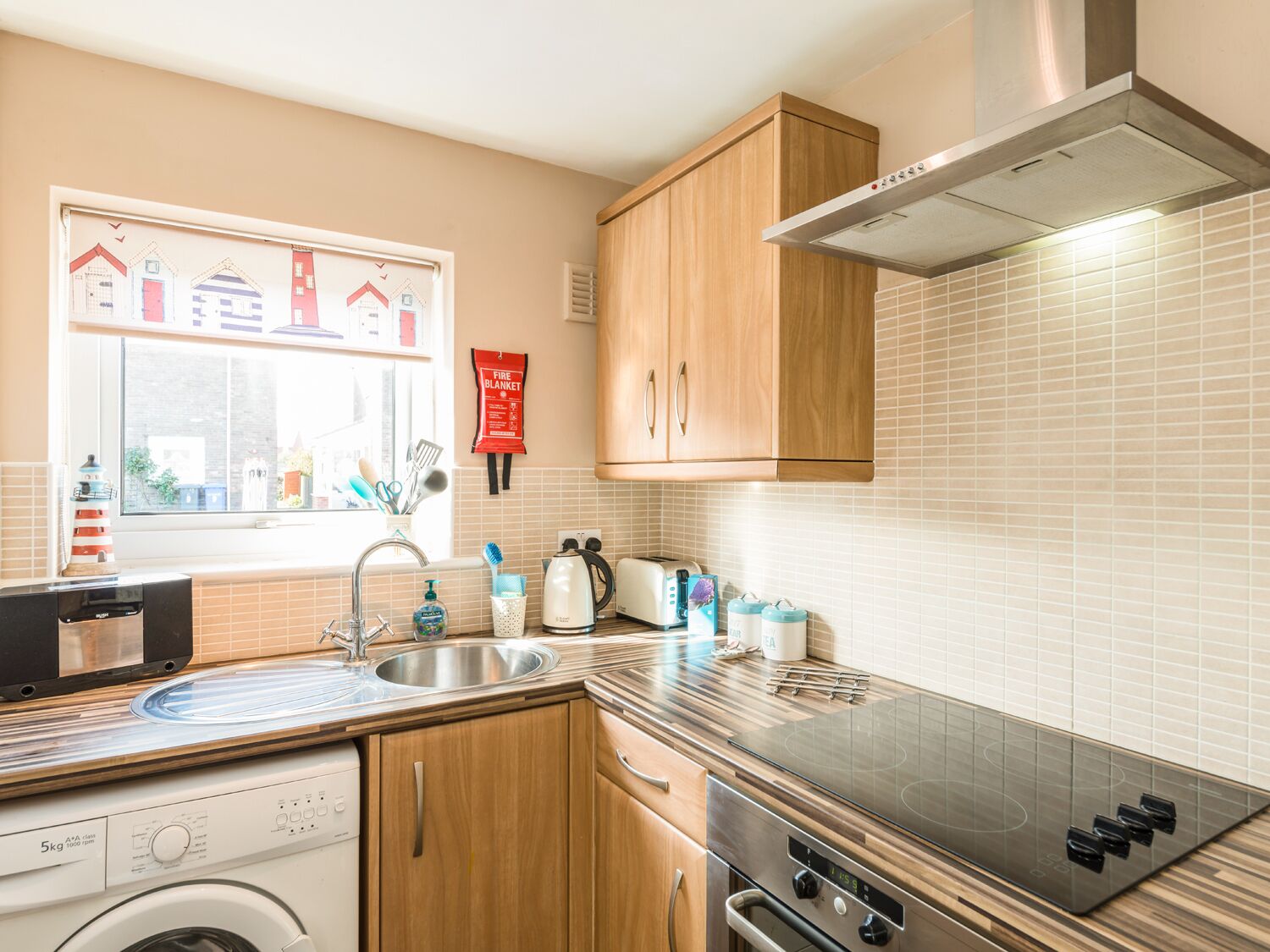 A modern kitchen with wooden cabinets, a stainless steel sink, and a built-in oven.
