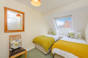 Relax in this serene bedroom with a single bed, a comfortable chair, and a mirror.