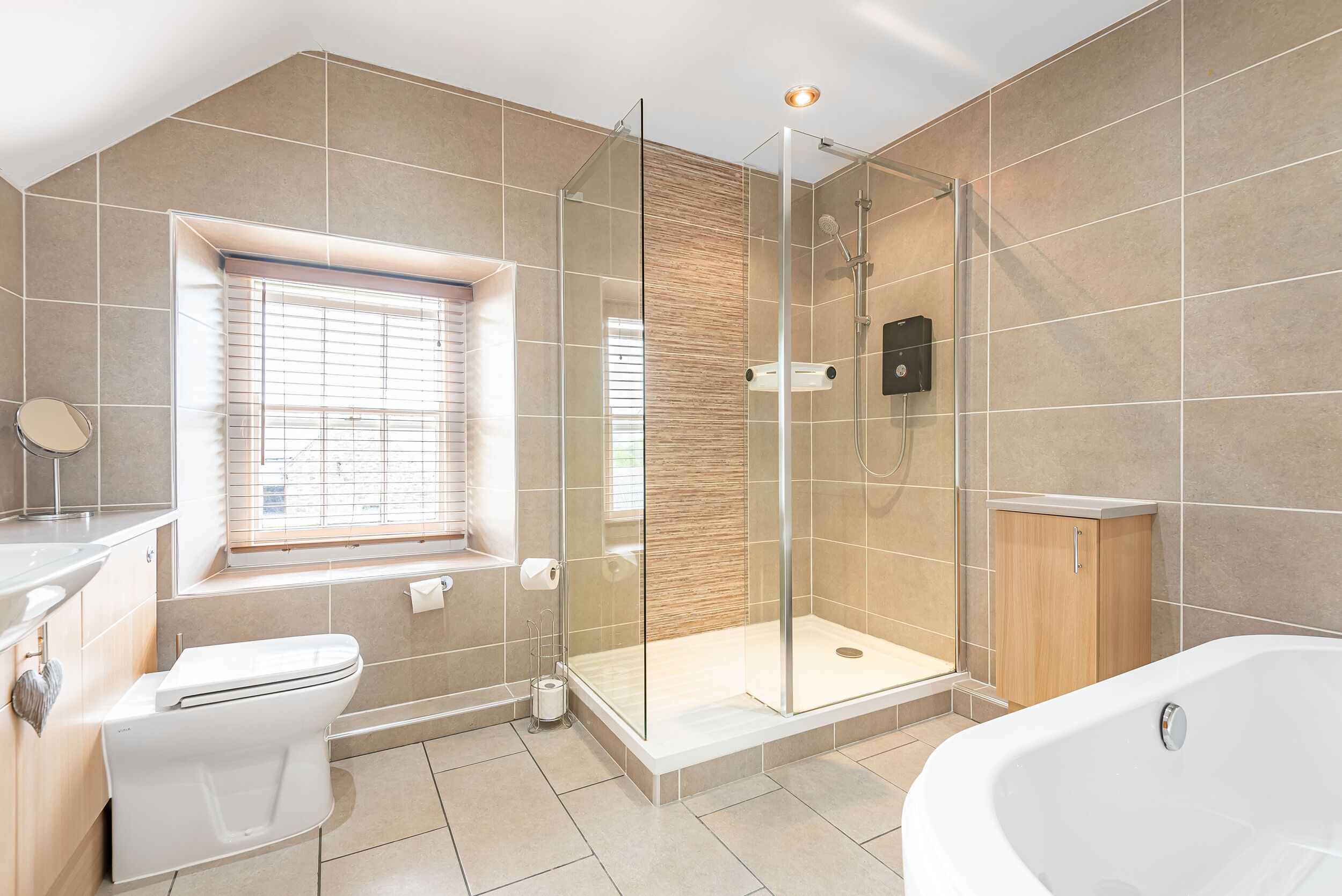 Une salle de bain moderne avec une douche à parois de verre, une baignoire blanche et des toilettes.