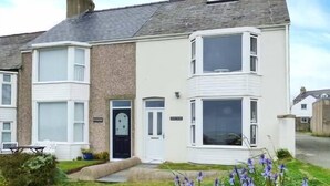 En toetages boligbygning med en karnap på første sal og et hjørnevindue på anden sal.