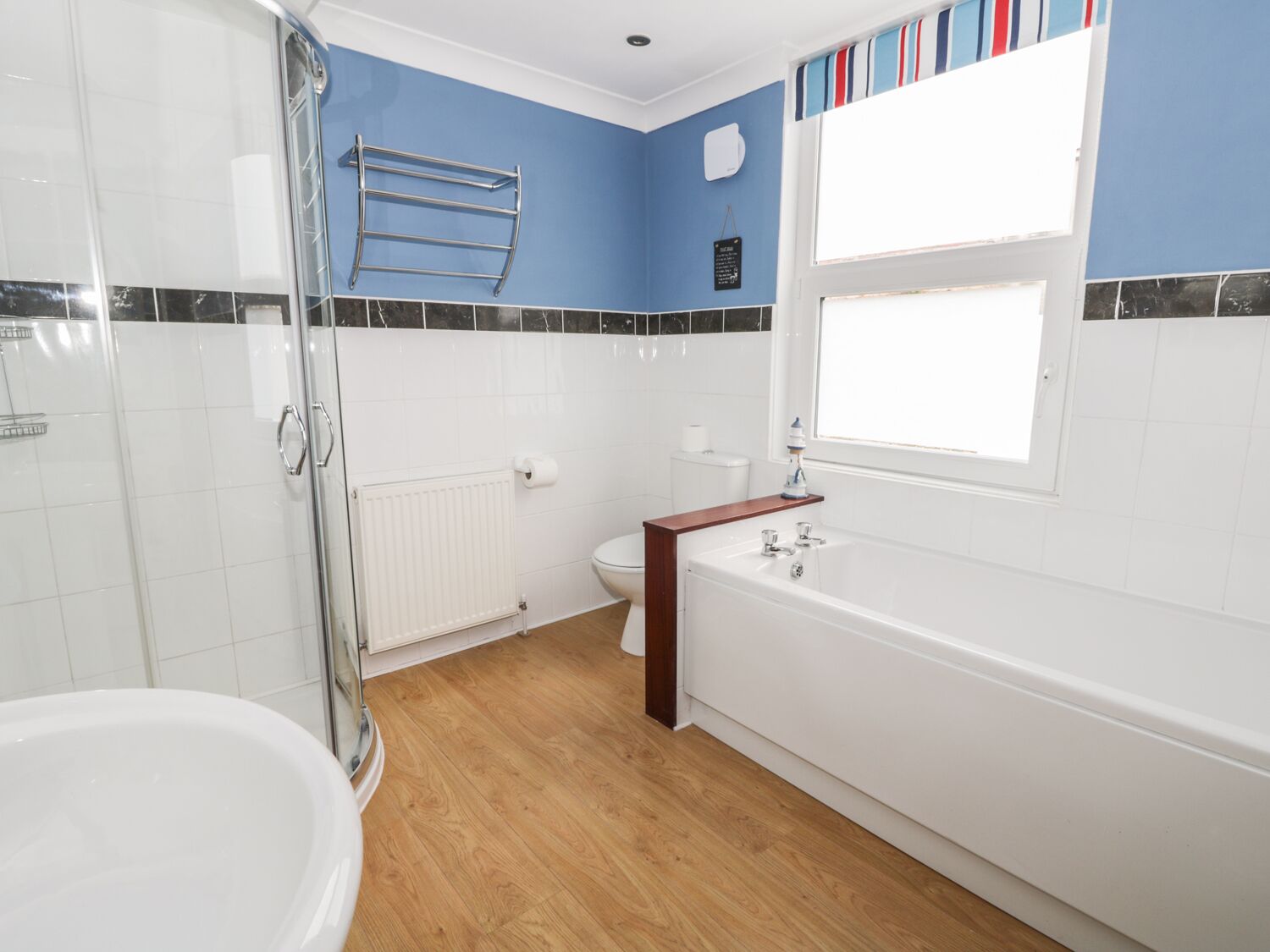 A bathroom with a shower, toilet, and bathtub.