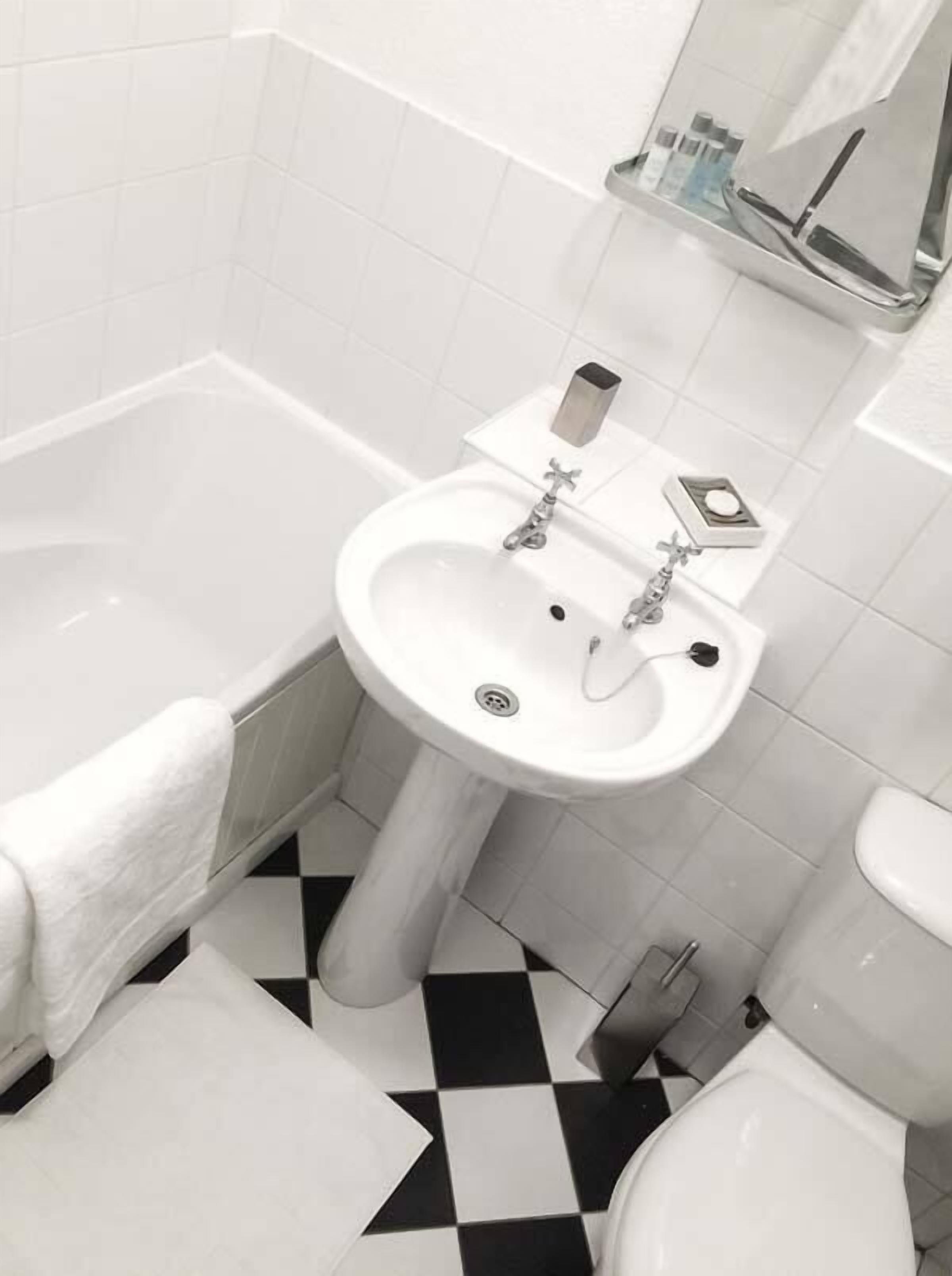 A bathroom with a white sink, a bathtub, and a toilet.