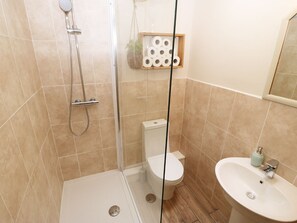 Une salle de bain avec douche, toilettes et lavabo.