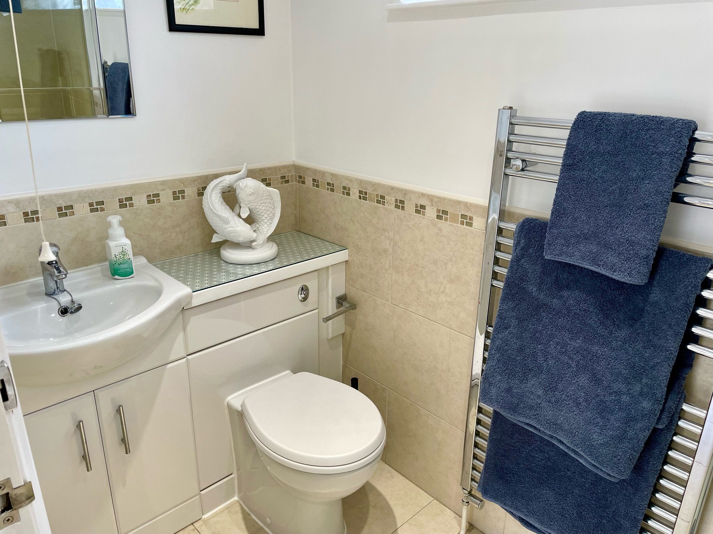 A bathroom with a sink, toilet, and towel rack.