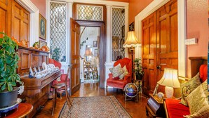 A traditional room with a wooden floor, a red sofa, a globe, and a lamp. - Clooneavin Apartment 8 (Lynmouth)