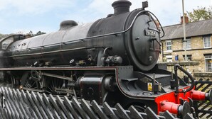 A steam locomotive with the number 61264, parked outdoors with a building in the background. - Station View (Pickering)