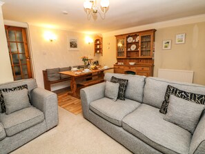 Relax in this stylish living room with a sofa, dining table, and cabinet.