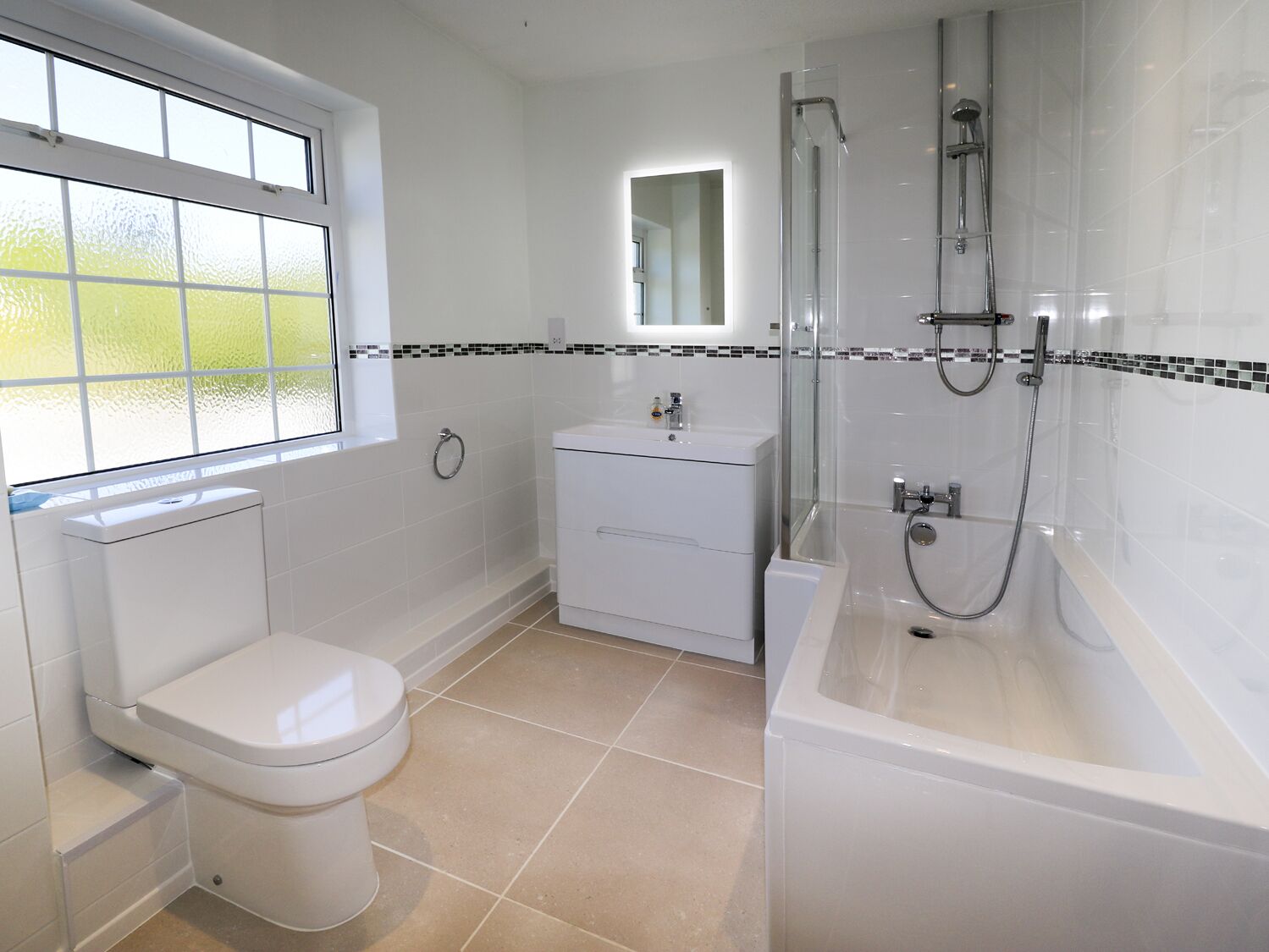 Een moderne badkamer met toilet, wastafel en douche.