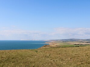 Enjoy breathtaking views of the sea and surrounding hills from this serene coastal landscape.