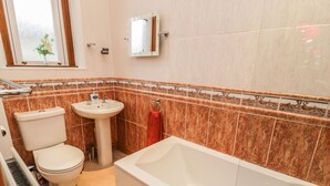 Une salle de bain avec des toilettes, un lavabo et une baignoire.