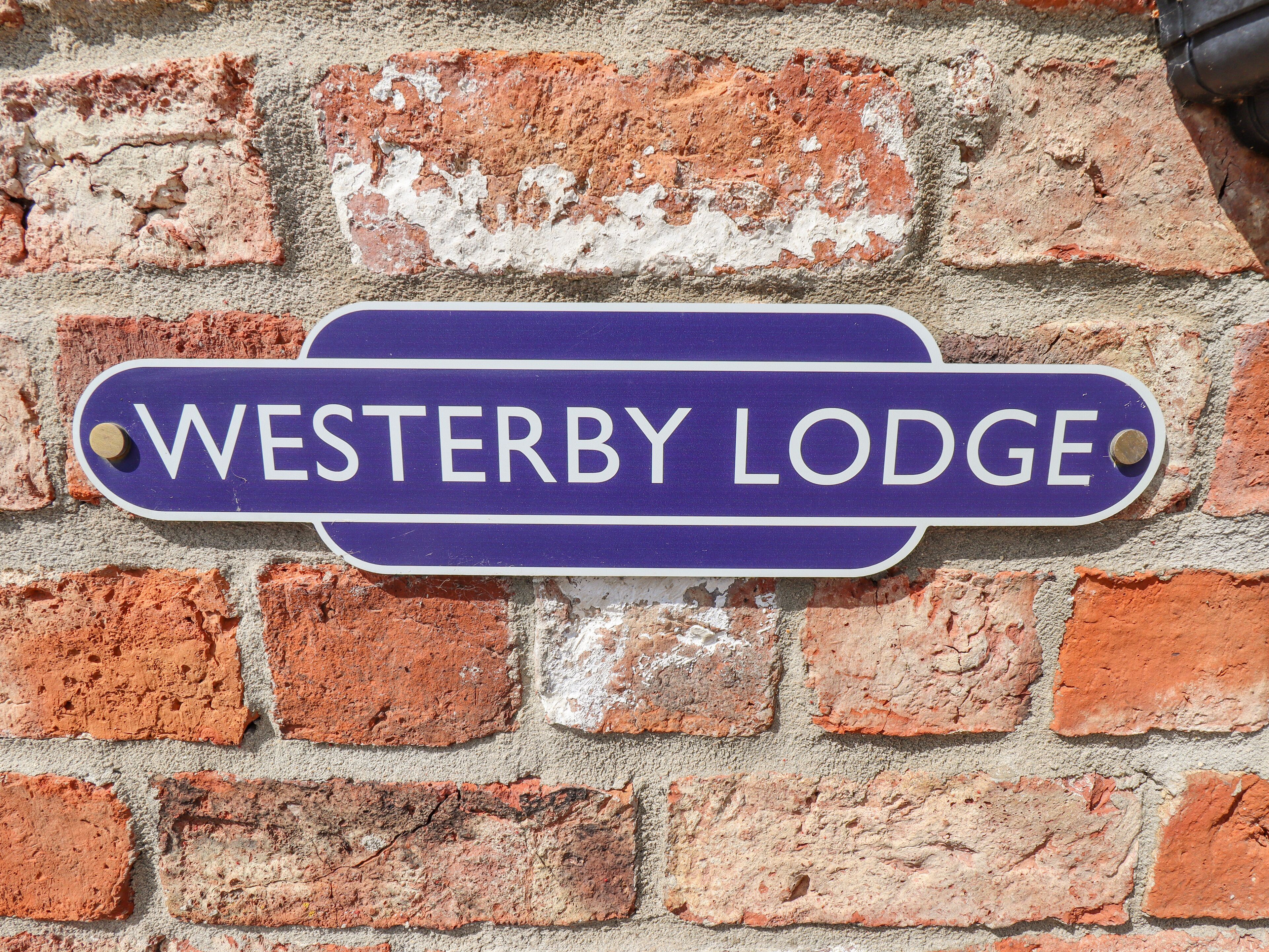 Un rètol amb la frase "WESTERBY LODGE" a una paret de maó.