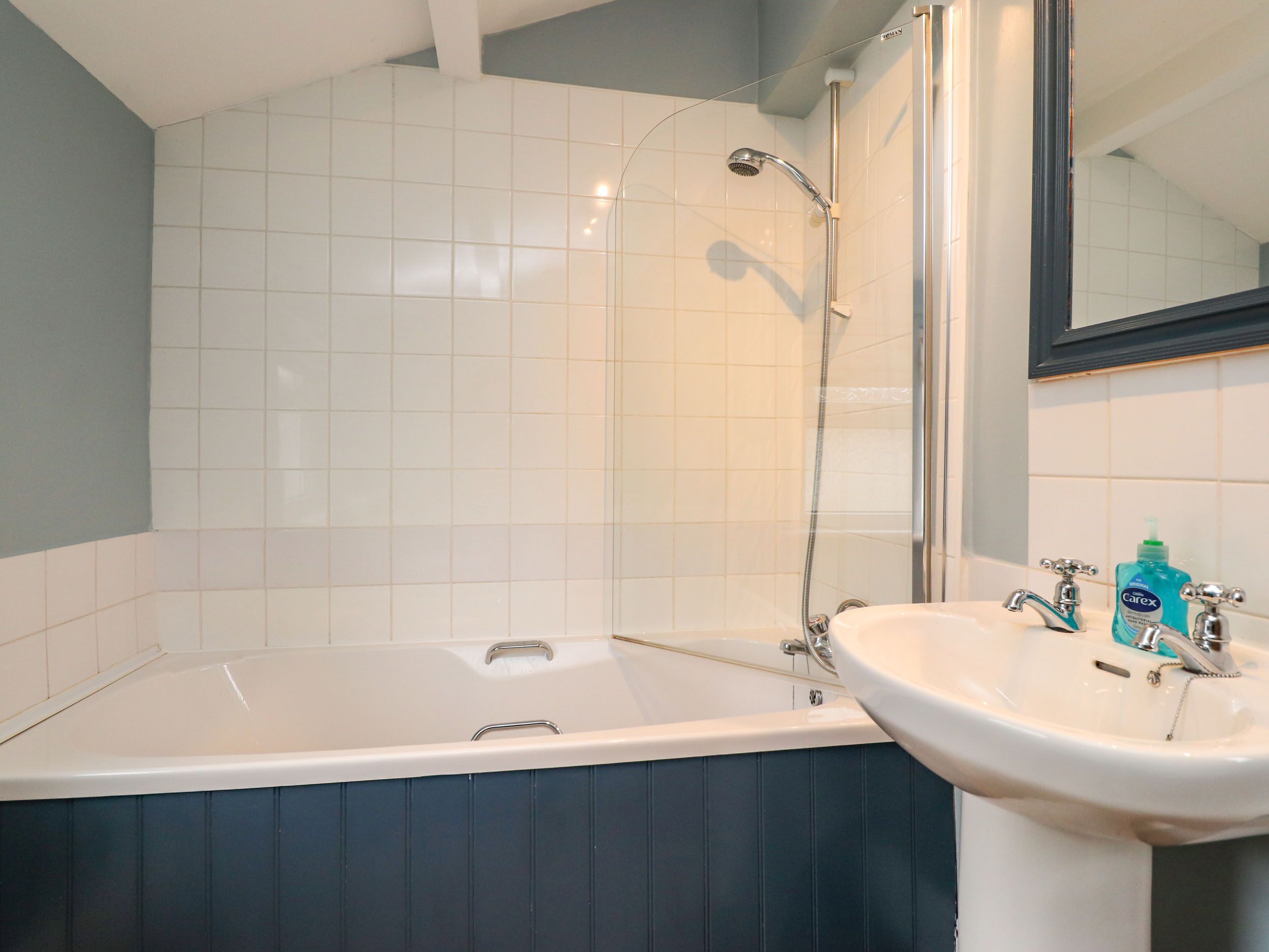 A bathroom with a bathtub, a sink, and a shower.