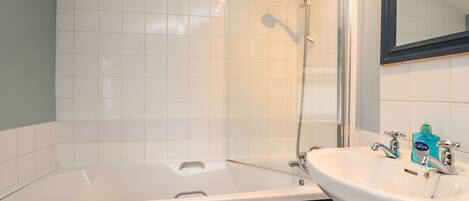 A bathroom with a bathtub, a sink, and a shower.