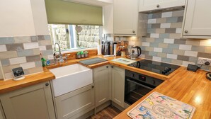 A modern kitchen with a built-in oven, a sink, and a window with a view of the outside.