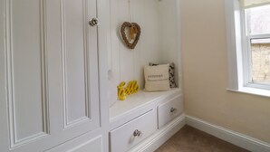 A white wardrobe with a heart-shaped decoration, a 'retreat' pillow, and a yellow 'hello' sign.