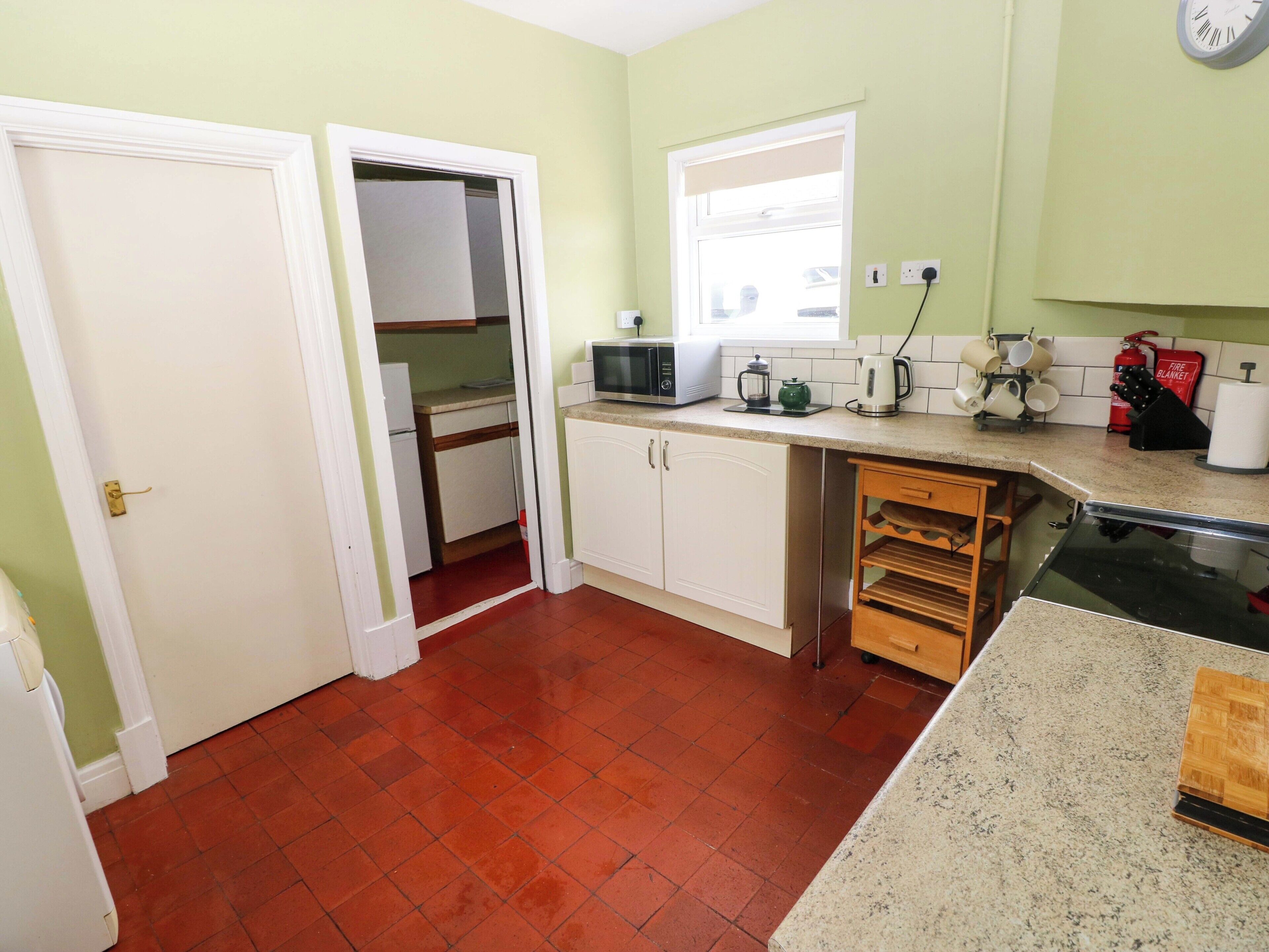 A compact kitchen with a refrigerator, microwave, and coffee maker.