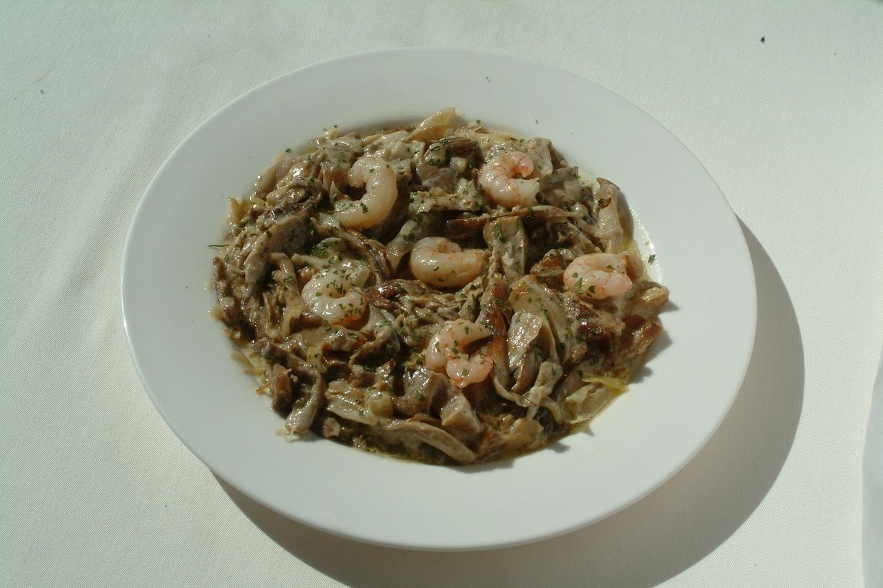 A plate of food with shrimp and vegetables on a white plate.