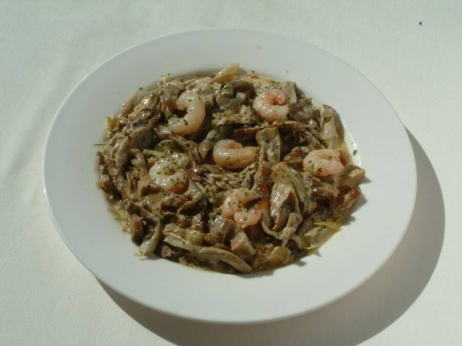 A plate of food with shrimp and vegetables on a white plate.