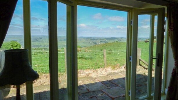 A room with a large sliding glass door leading to a grassy field.