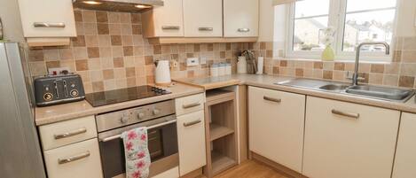 Cottage | Privékeuken | Een magnetron, een vaatwasser, kookgerei, borden en bestek