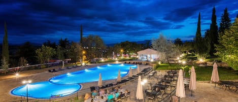 Una piscina al aire libre, sillones reclinables de piscina