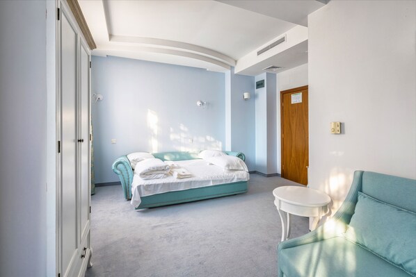 Une chambre à coucher avec un lit, une chaise, une petite table et une porte.