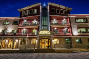 Un hotel de varios pisos con una entrada destacada y balcones.