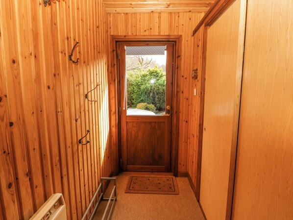 Ein Korridor mit Holzboden und einer Tür zu einem Fenster.