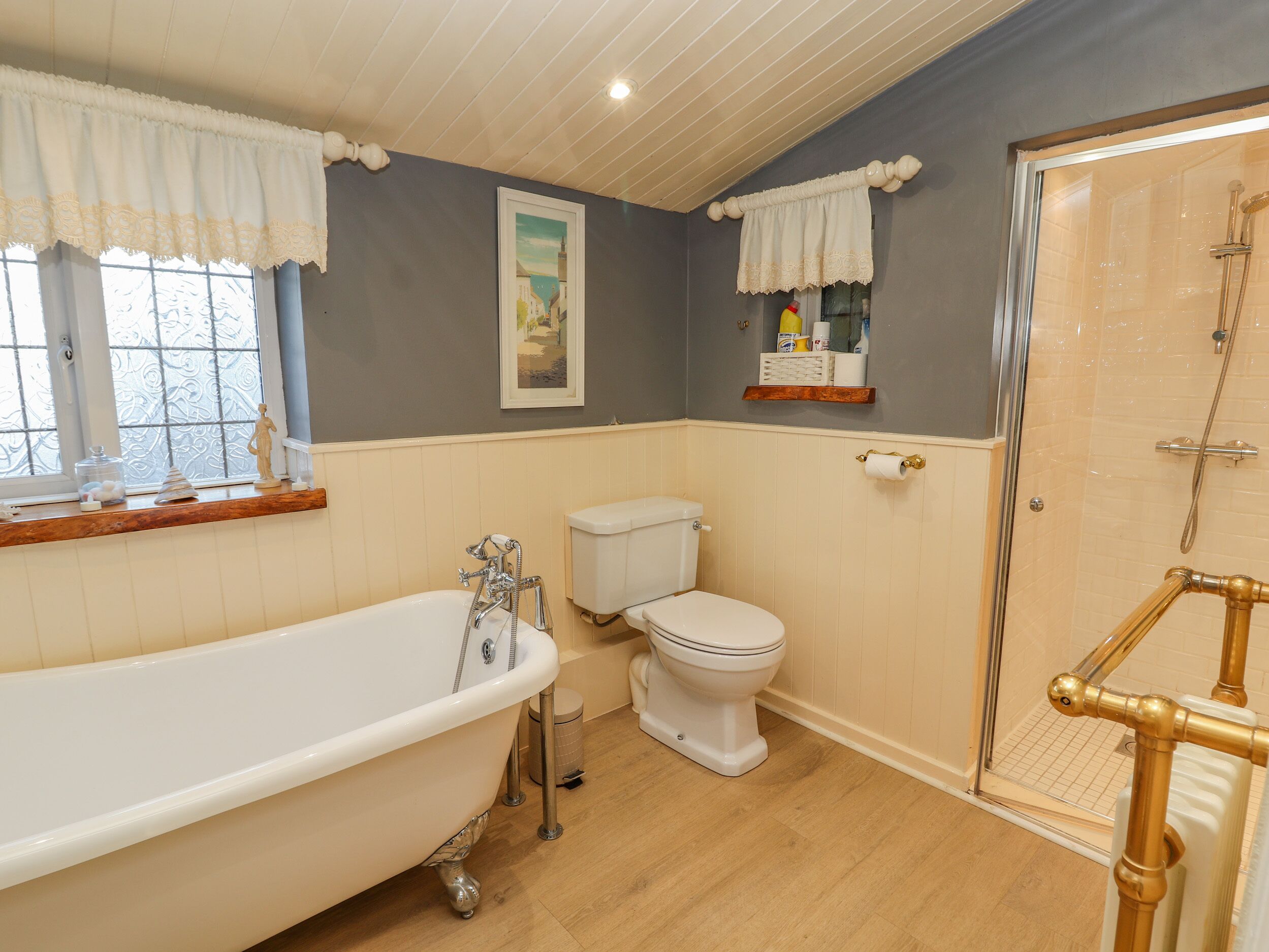 A bathroom with a freestanding bathtub, a toilet, and a glass-enclosed shower area.