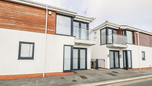 A modern two-story residential building with a flat roof, large windows, and a balcony on the upper floor. - 7 Marina View (Pwllheli)