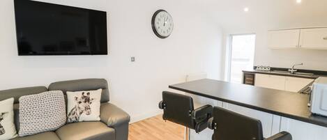 Een modern appartement met een zithoek, eethoek en keuken.